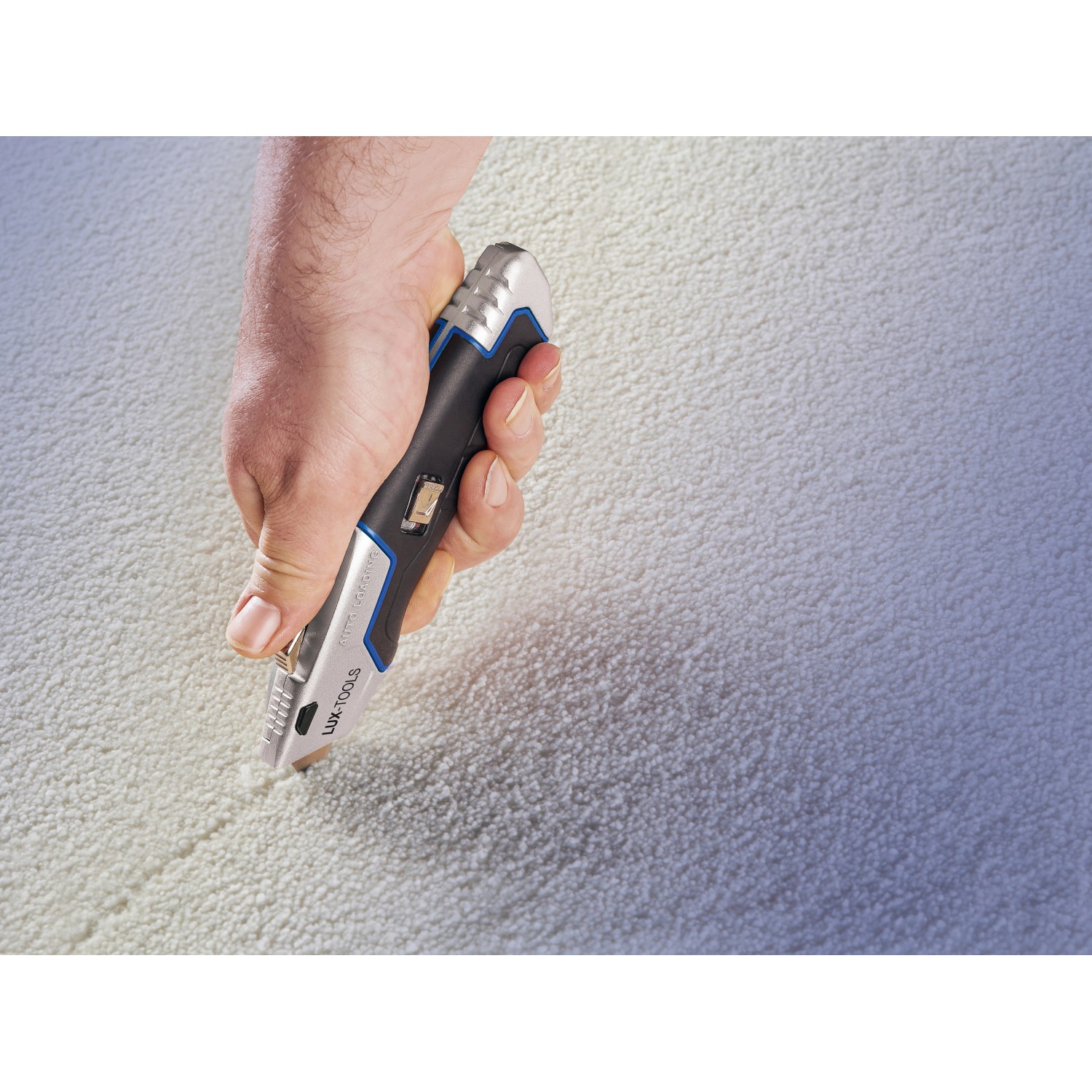 LUX Universalmesser Comfort schneidet Teppich. Messer mit schwarzem Griff und silberner Klinge.