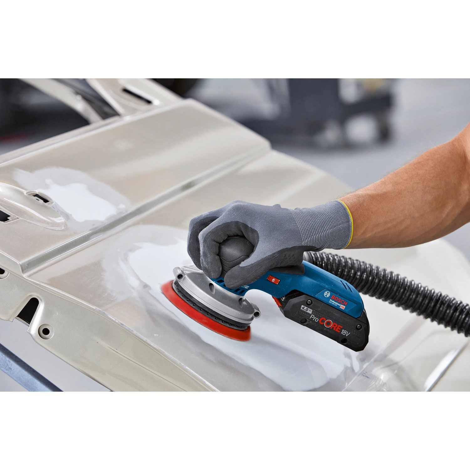 Bosch Professional Akku-Exzenterschleifer GEX 18V-125 im Einsatz beim Schleifen einer Autotür.