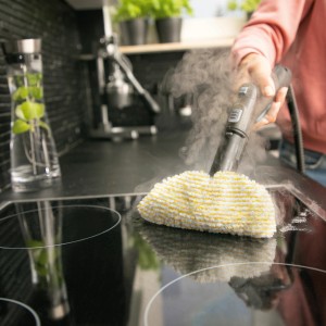 Kärcher Dampfreiniger SC 2 EasyFix in Aktion: Reinigt ein schwarzes Kochfeld mit Dampf.