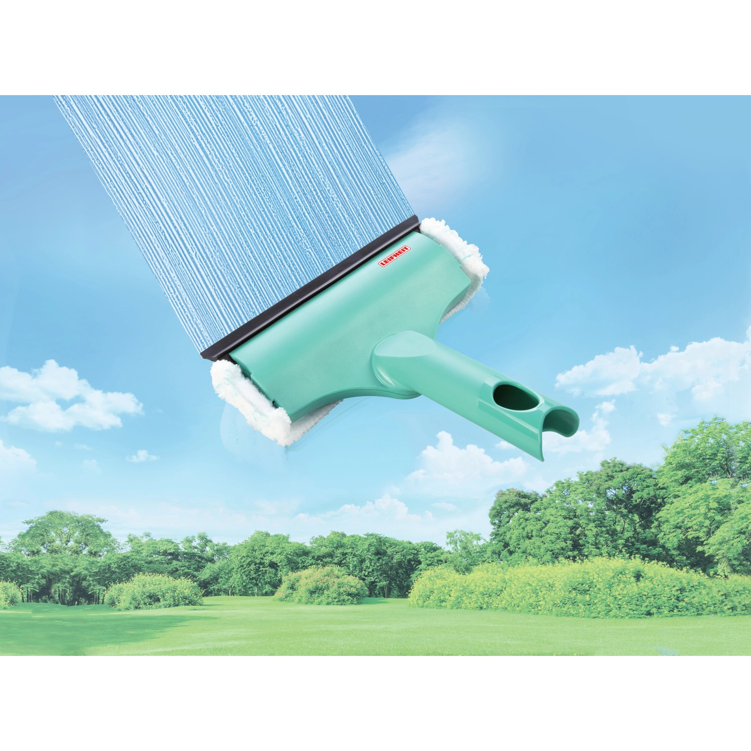 Leifheit Fensterwischer 3 in 1 Mini, mintgrün, mit Mikrofaserbezug und Abziehlippe vor blauem Himmel.
