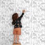 Kind berührt weiße Vliestapete mit grauen Dschungeltieren wie Elefanten, Zebras. Ideal für Kinderzimmer.