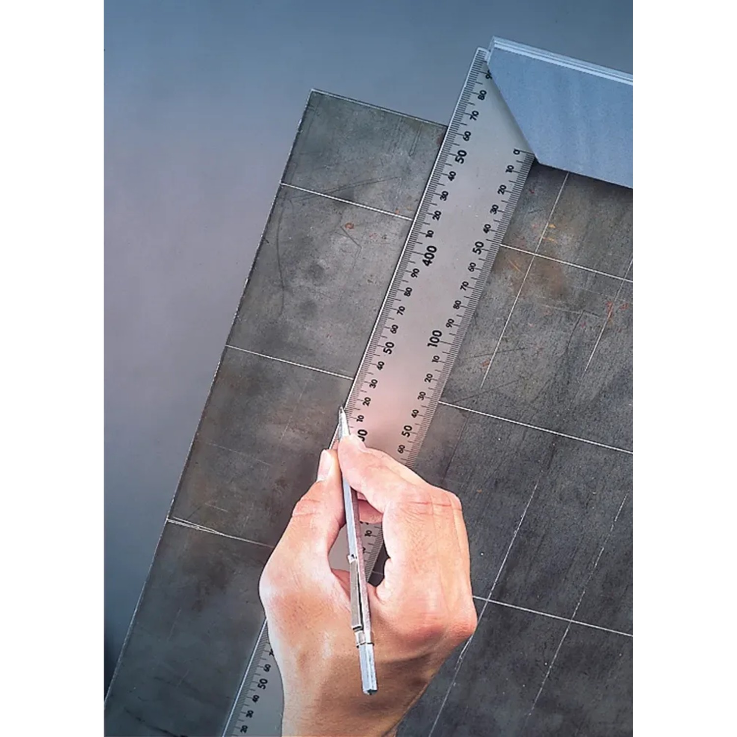LUX Reißnadel Classic 140 mm beim Anreißen einer Linie auf Metall mit einem Lineal.