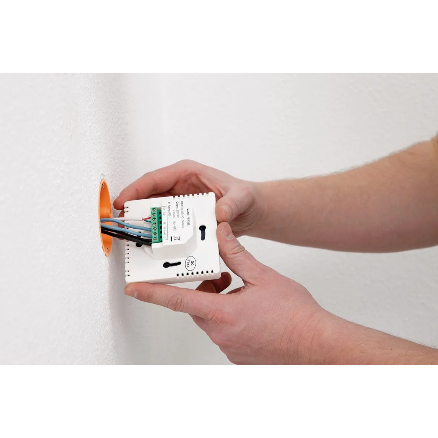 Installation einer Heizfolie Fußbodentemperierung: Detailaufnahme des Temperaturreglers an der Wand.