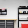 Schwarzes Schwerlastregal aus Stahl und MDF in Werkstatt. Höhenverstellbare Böden, teilbar, mit Werkzeug und Reifen.