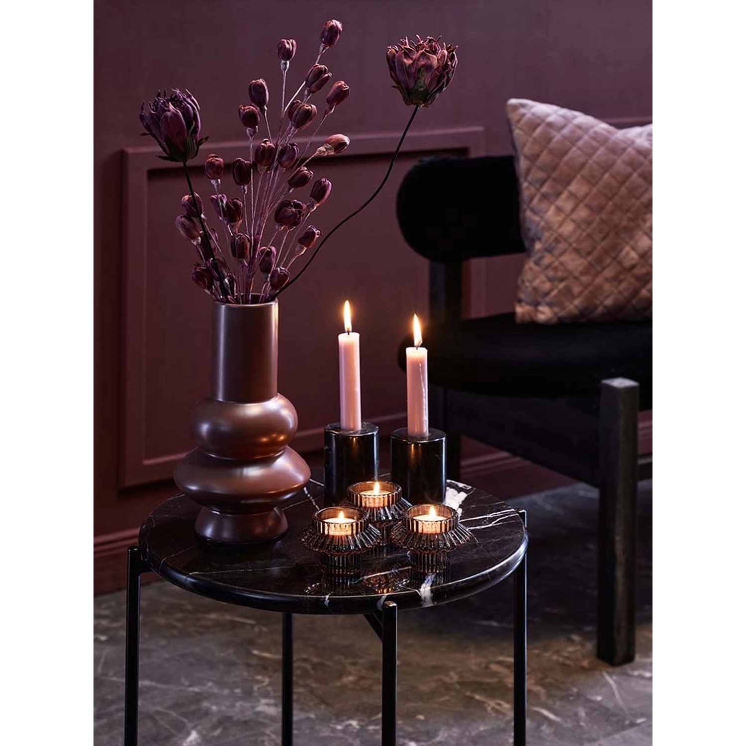 Dekostrauß Lilie Midnight Mystery in Lila-Schwarz in Vase, Kerzen und Teelichthalter auf Tisch.