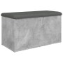 Betongraue Sitzbank mit Stauraum und dunklem Polsterkissen. Möbel für Flur oder Wohnzimmer.