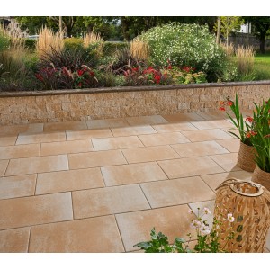 Verona Terrassenplatten in Sandsteingelb auf Terrasse mit Bepflanzung.