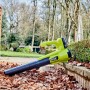 Ryobi Akku-Laubgebläse RY18BLA-140 One+ mit Akku und Ladegerät im Garten.