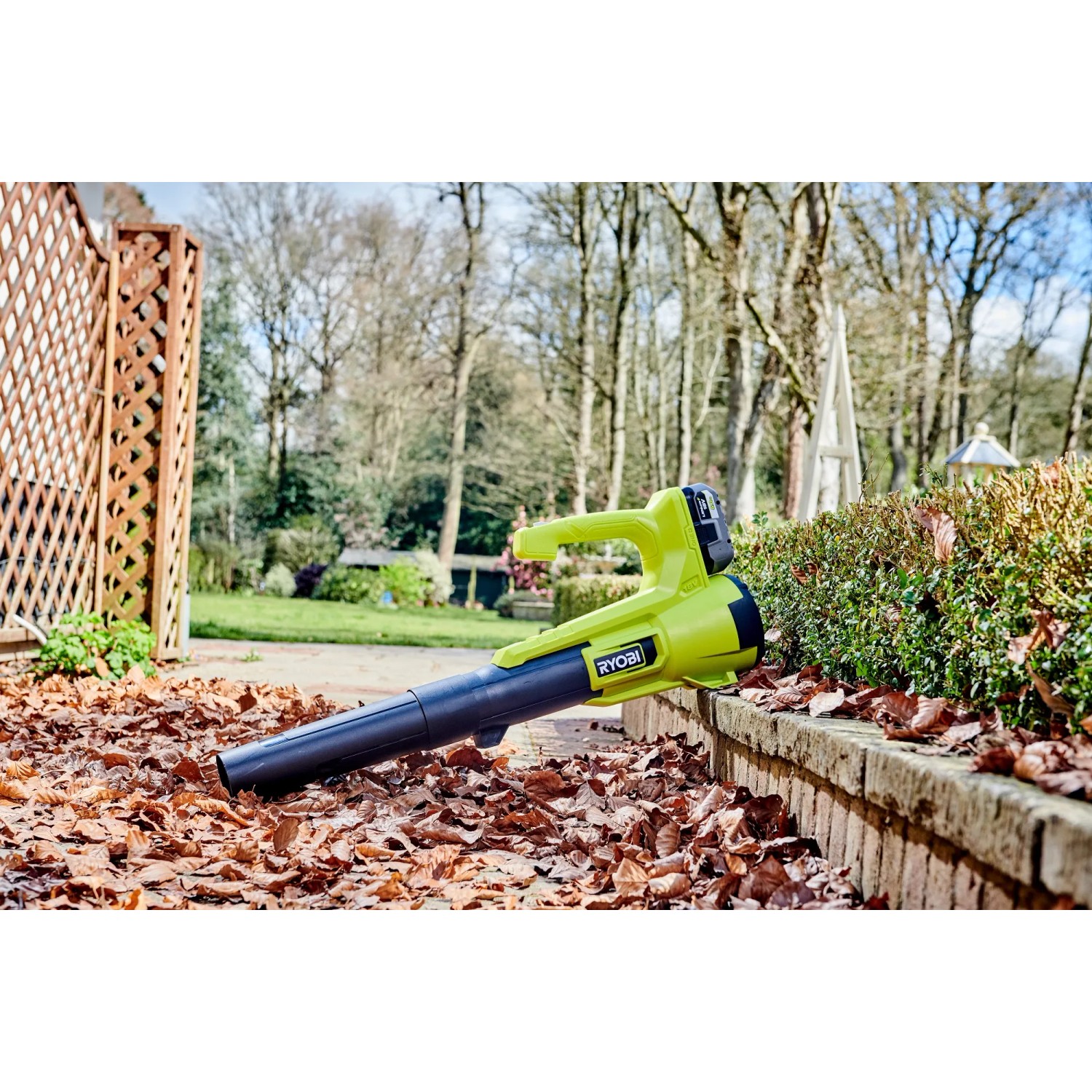 Ryobi Akku-Laubgebläse RY18BLA-140 One+ mit Akku und Ladegerät im Garten.
