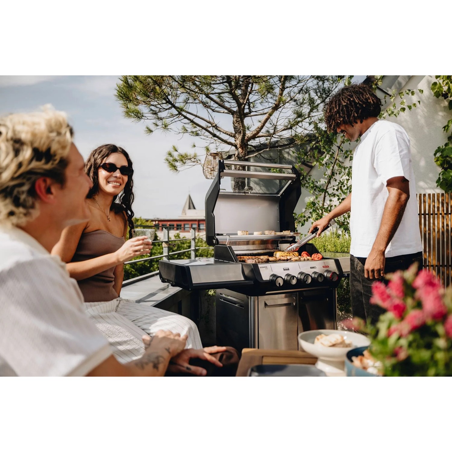 Enders Gasgrill Monroe Pro 3 SIKR Turbo beim Grillen mit Freunden im Freien.