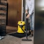 Gelber Kärcher Nass-/Trockensauger WD 3 V-17/4/20 im Einsatz vor einer Haustür.