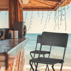 Zwei graue klappbare Barhocker aus Kunststoff in Rattanoptik mit Stahlrahmen, am Strand. Ideal für Garten & Terrasse.
