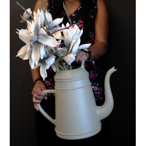 Olivgraue Gießkanne Lungo 12L mit Blumen, gehalten von einer Person.