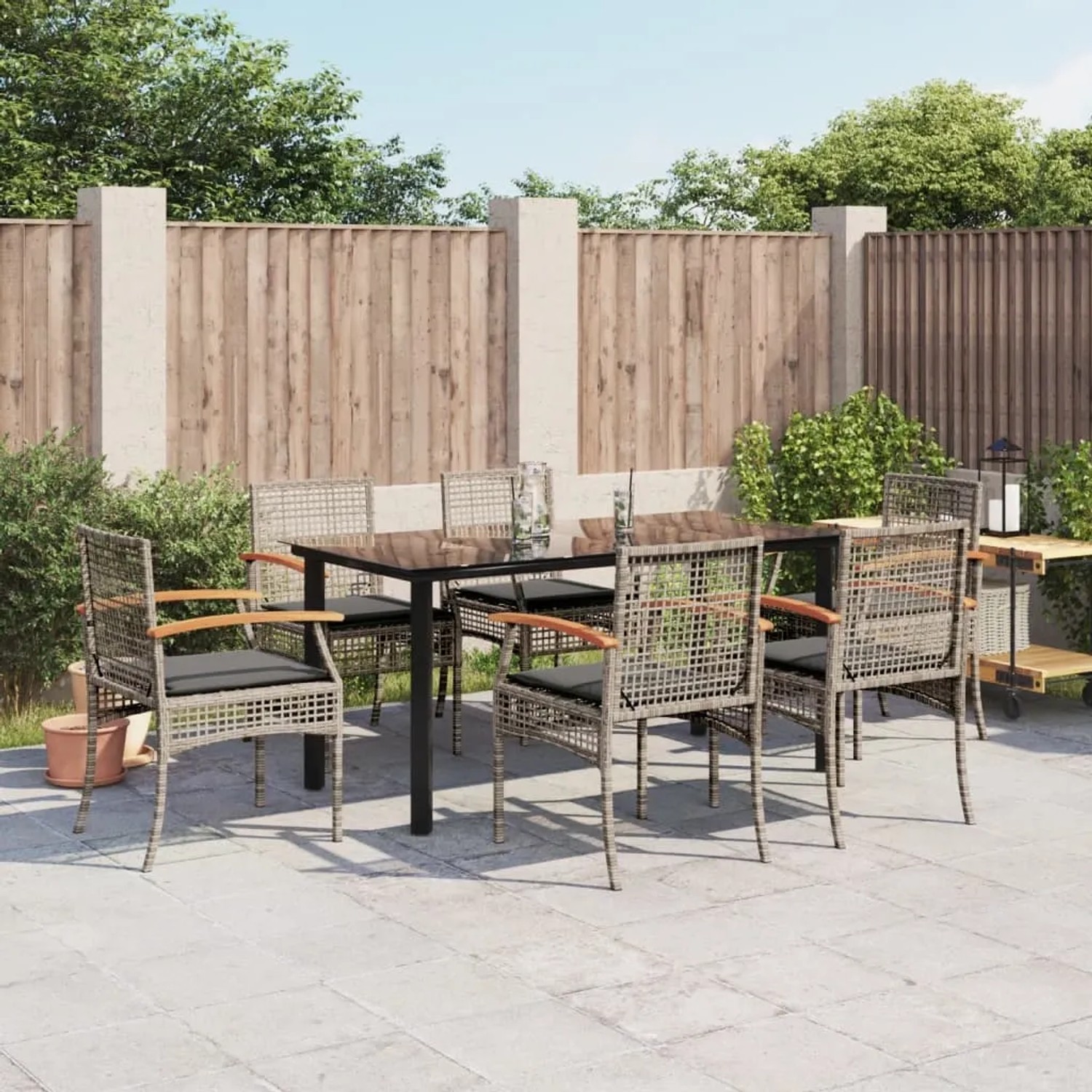 7-tlg. Garten-Essgruppe mit grauen Polyrattan-Stühlen und schwarzem Tisch für den Außenbereich.