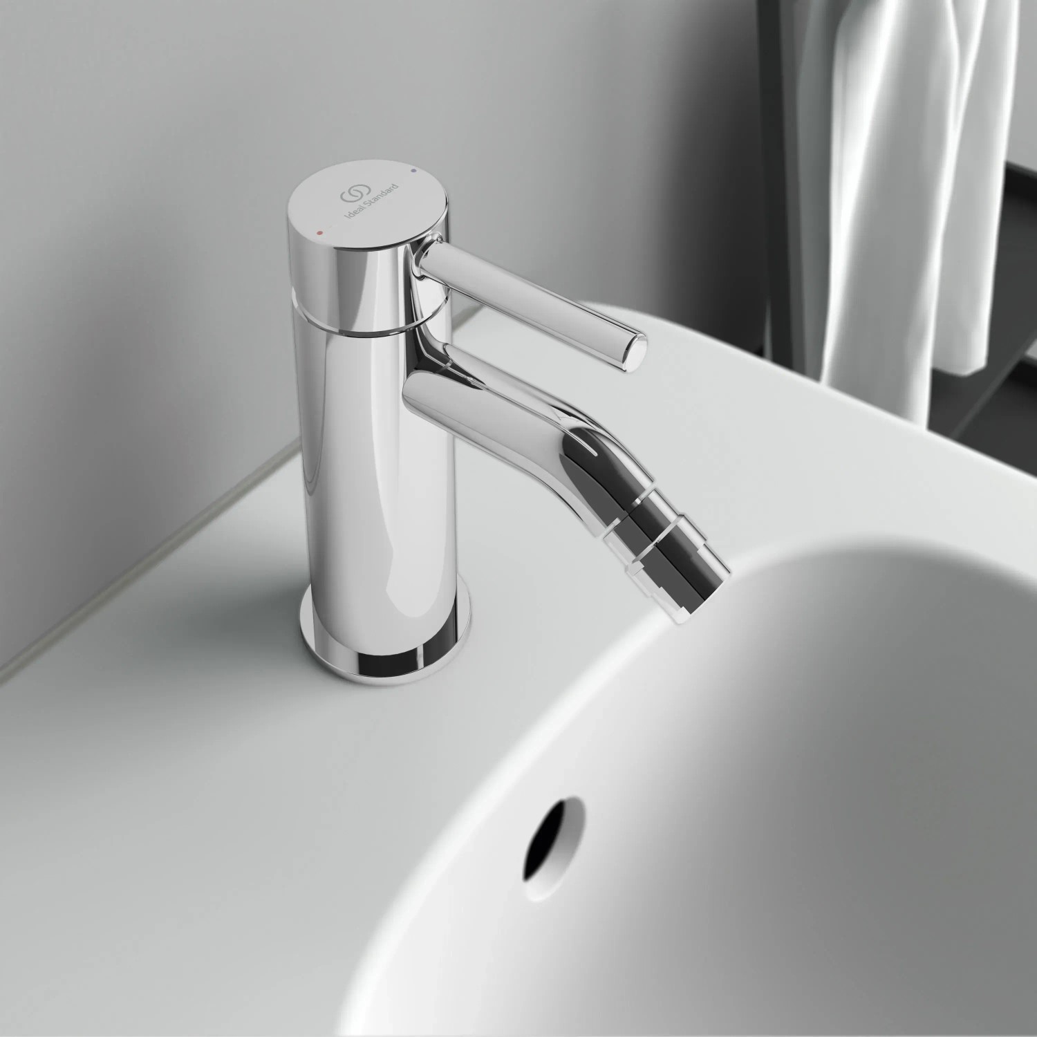 Ideal Standard Ceraline Bidetarmatur in Chrom auf einem weißen Bidet.