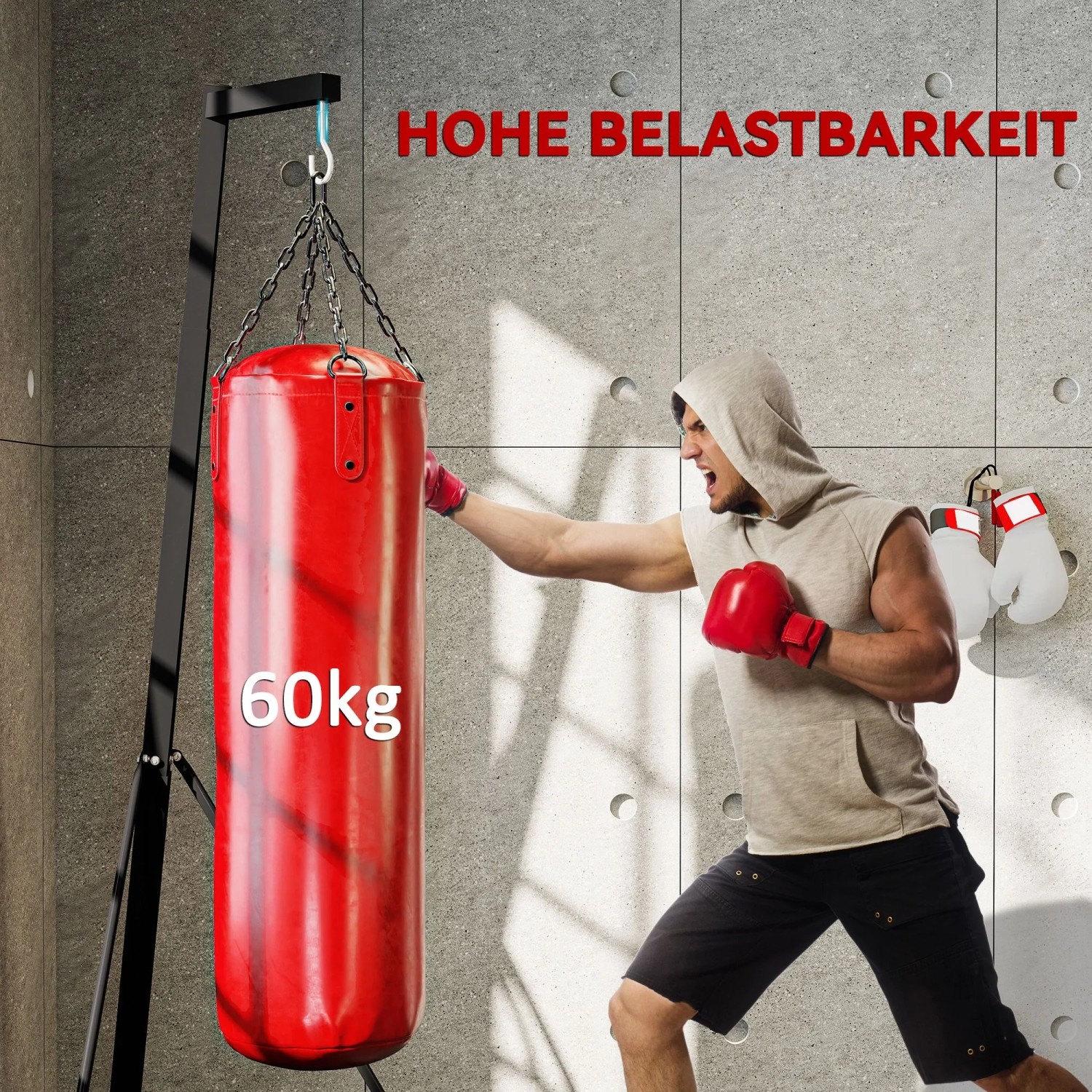 Schwarzer, klappbarer Boxsackständer aus Stahl mit rotem 60kg Boxsack. Ein Mann trainiert daran. Höhenverstellbar für Fitness.