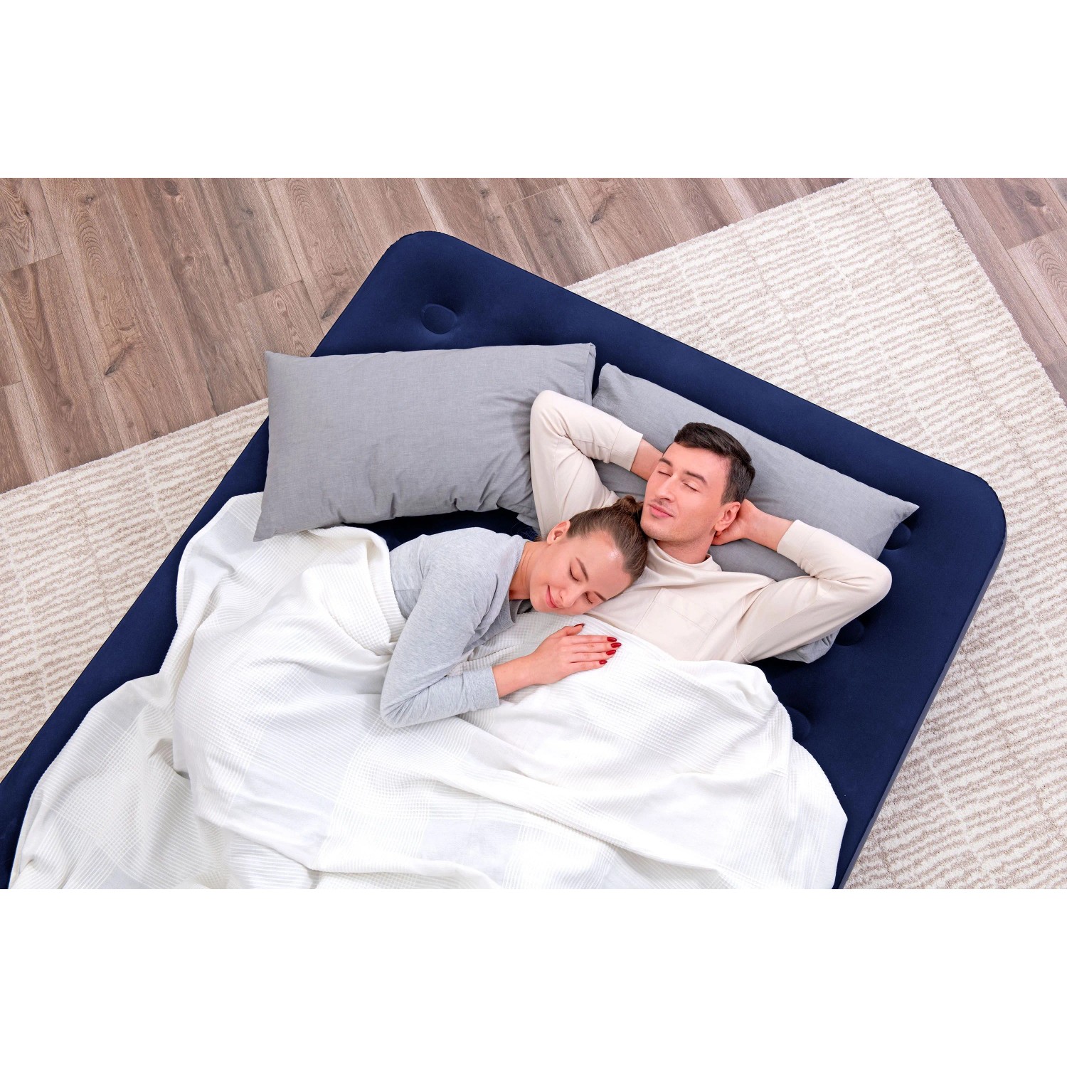 Bestway Luftmatratze Queen Size, dunkelblau, mit Paar unter weißer Decke. Camping & Gästebett.