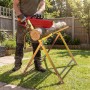 Mann sägt Holz mit Kettensäge auf verzinktem, zusammenklappbarem Wiltec Sägebock im Garten. Sicherer Arbeitsbock für Brennholz.