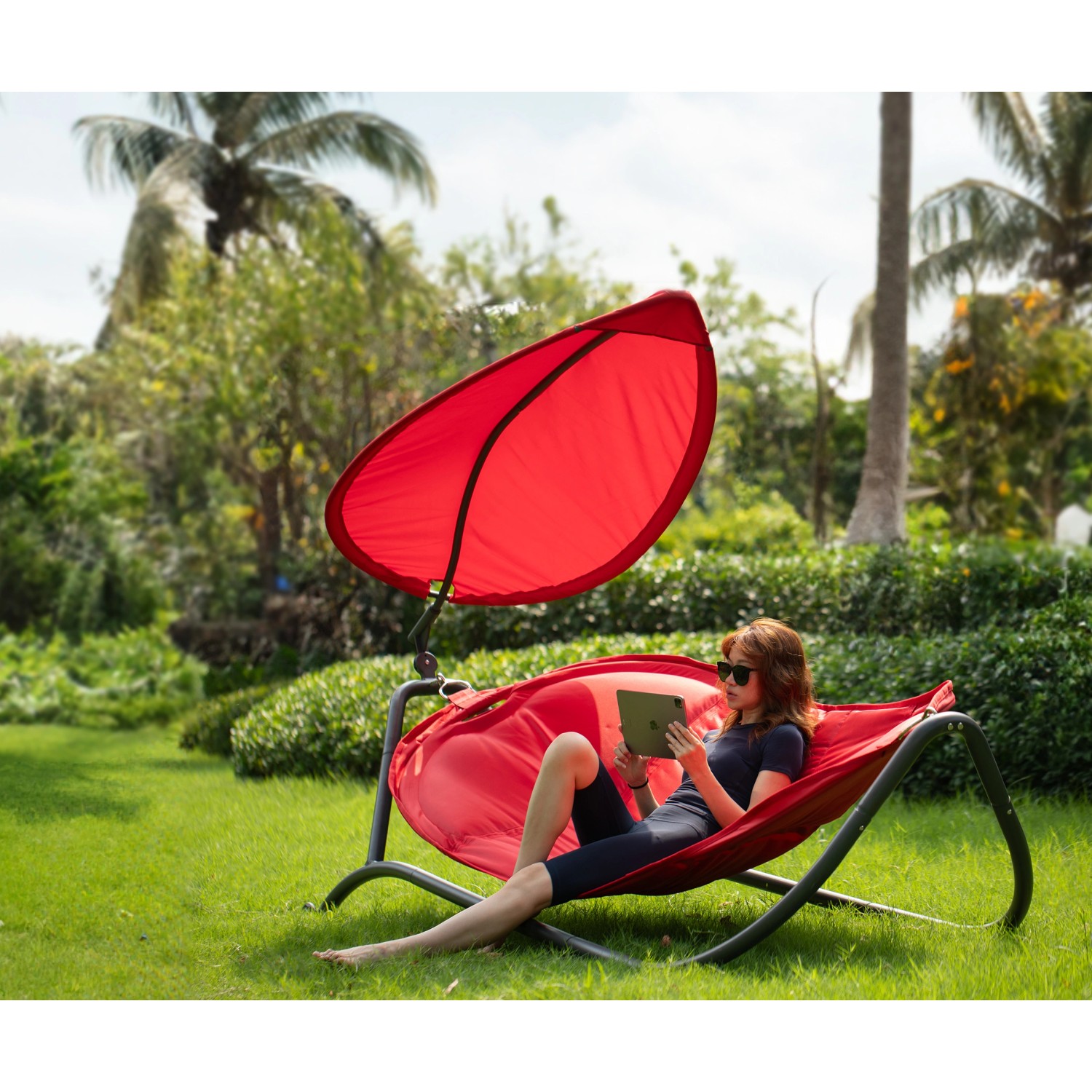 Rote Leco Luxus-Hängematte Gloria mit Sonnendach im Garten. Bequeme Sonnenliege zum Entspannen.