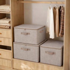 Drei beige Stoffboxen mit Deckel und Griffen im Holzschrank als Organizer für Kleidung und Ordnung.
