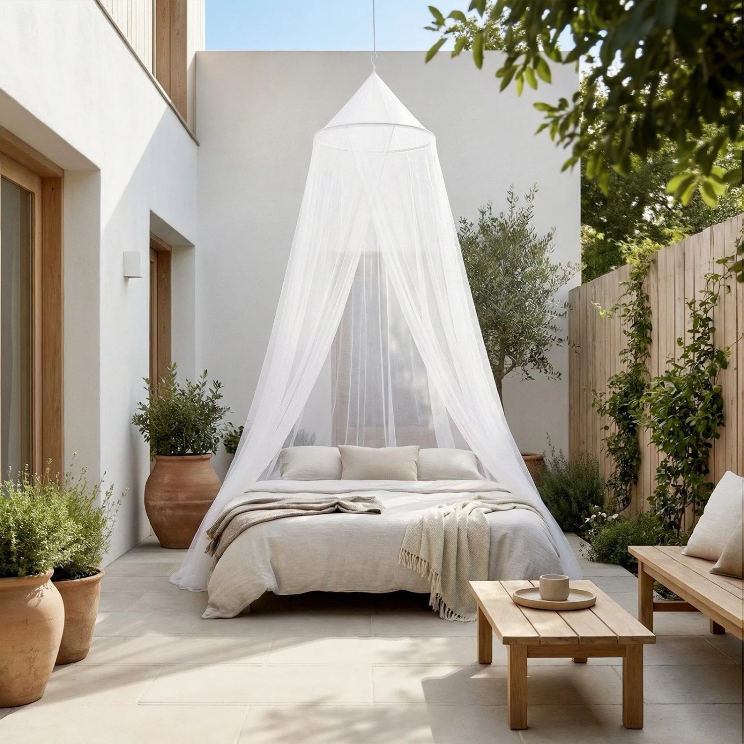 Weißes Moskitonetz über einem Doppelbett auf einer Terrasse. Ideal als Insektenschutz für Outdoor, Reise & Camping.