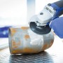 LUX Fiberscheibe Classic im Einsatz mit Winkelschleifer zum Bearbeiten eines Metallrohrs.