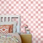 ESTAhome Vliestapete mit rosa-weißem Karomuster an einer Schlafzimmerwand, neben einem Bett.