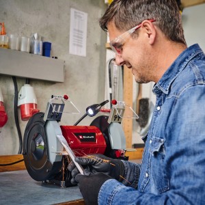 Einhell Doppelschleifer TC-BG 200 L im Einsatz: Mann schleift Werkstück mit Funkenschutz und LED-Licht.