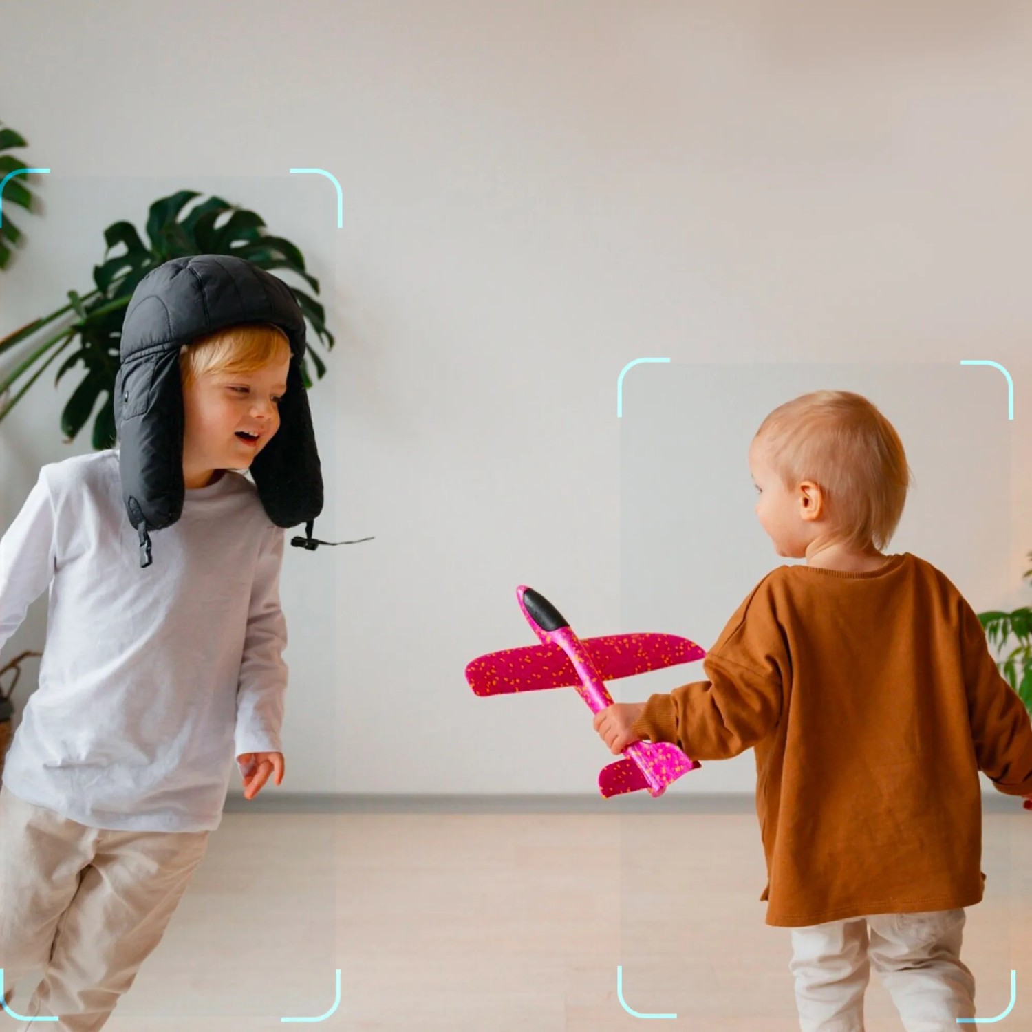 Kinder spielen mit Spielzeugflugzeug im überwachten Raum, Eufy Innenkamera C220 im Einsatz.