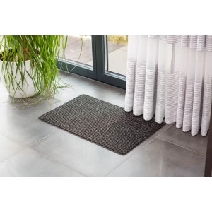 Anthrazitfarbene Astra Türmatte Rib Line Sprint 40x60 cm vor einer Tür.