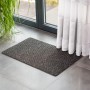 Anthrazitfarbene Astra Türmatte Rib Line Sprint 40x60 cm vor einer Tür.