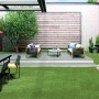 Satte, grüne Primaflor Kunstrasen Megan Fläche im Garten mit Möbeln und Dekoration.