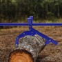 Blauer Xpotool 5-in-1 Holzheber hebt einen Baumstamm im Wald. Multifunktionaler Stammheber für Forstarbeiten bis 50 cm Ø.