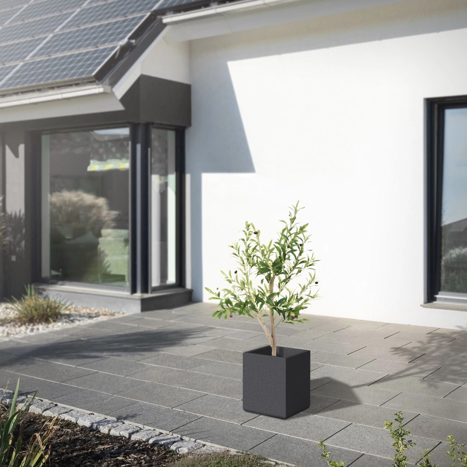 ML-Design künstlicher Olivenbaum (120cm) im Topf mit Holzstamm vor Hauswand.