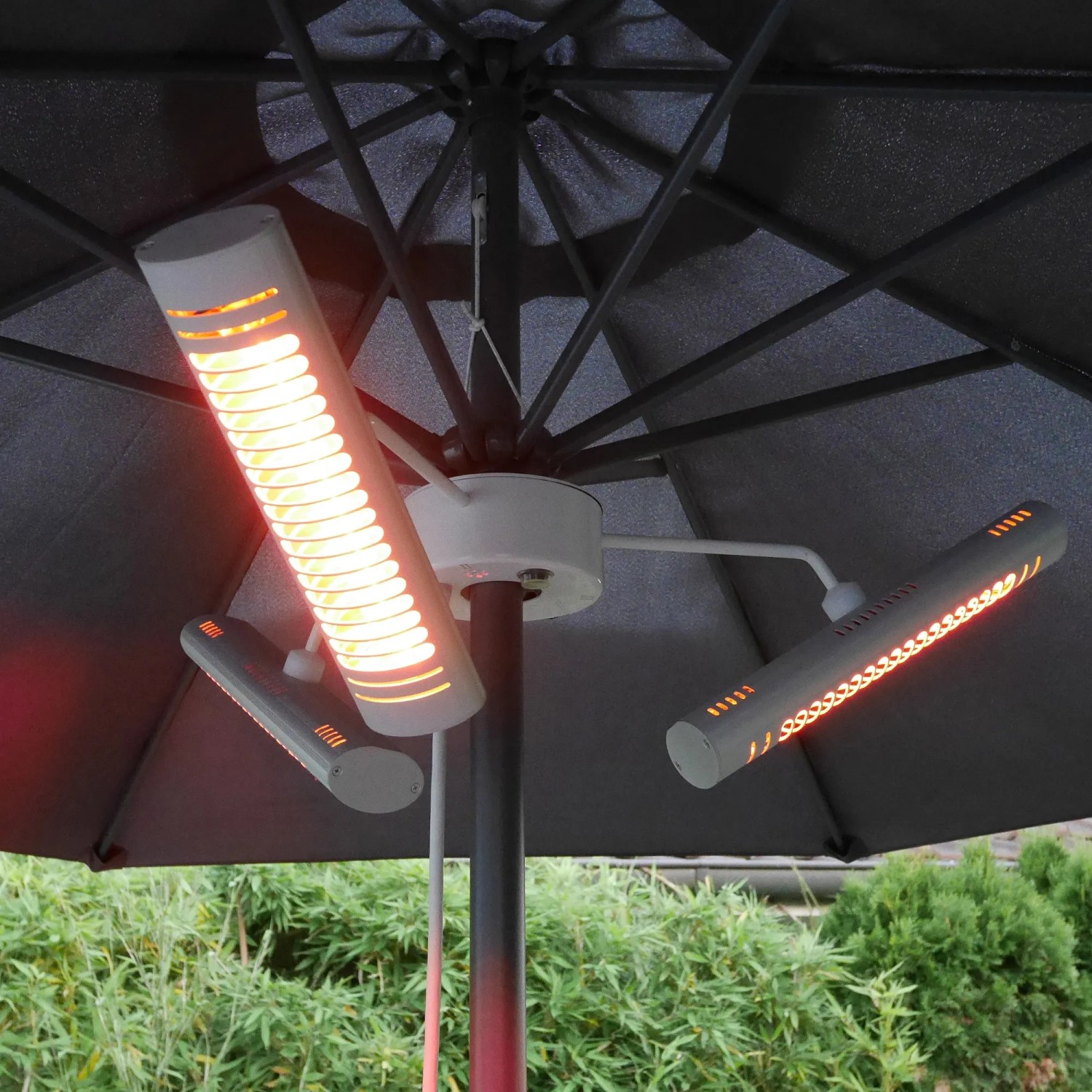 Vasner Schirm-Heizstrahler Umbrella X30 (3 Stk.) in Silber unter einem Sonnenschirm. Elektrische Heizgeräte für den Außenbereich.