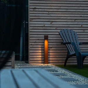 Rostbraune QAZQA Baleno Stehlampe für den Außenbereich, 65 cm hoch, neben einer Holzverkleidung.