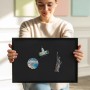 Schwarze Tulup Magnettafel 100x70 cm mit Reisemagneten, gehalten von einer Person.
