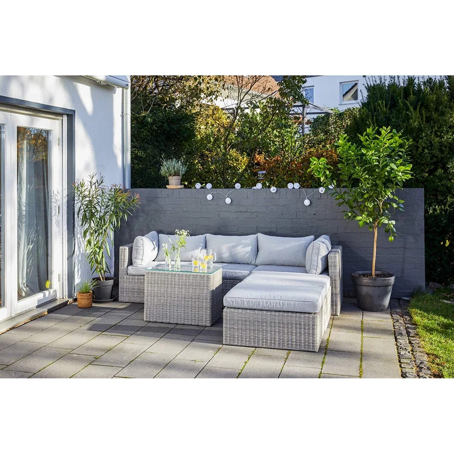 Lounge-Gartenmöbel: Modulare Olea Polyrattan Lounge-Sessel-Kombination in Sand mit hellgrauen Kissen.