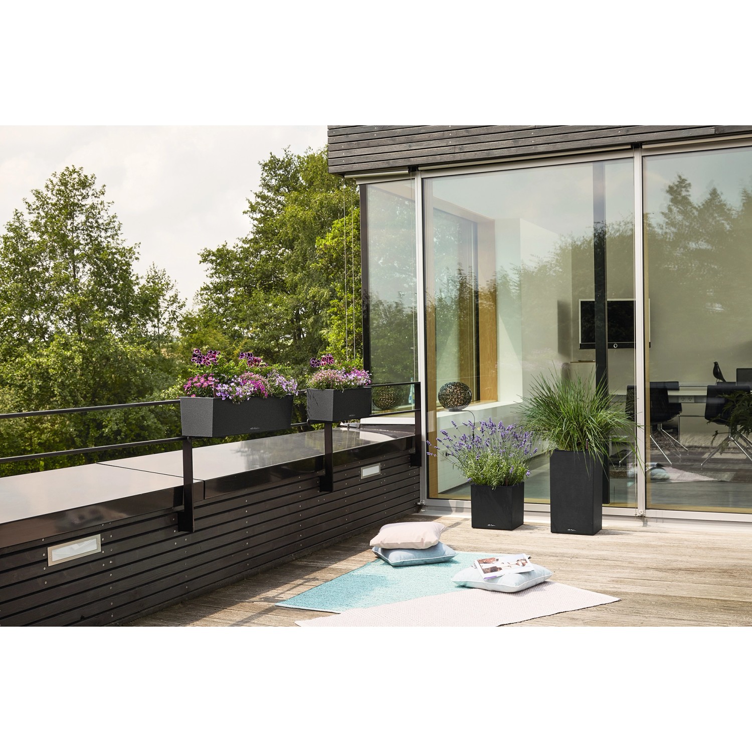 Lechuza Balconera Stone 50, graphitschwarzer Blumenkasten mit Bewässerungssystem auf Balkon.