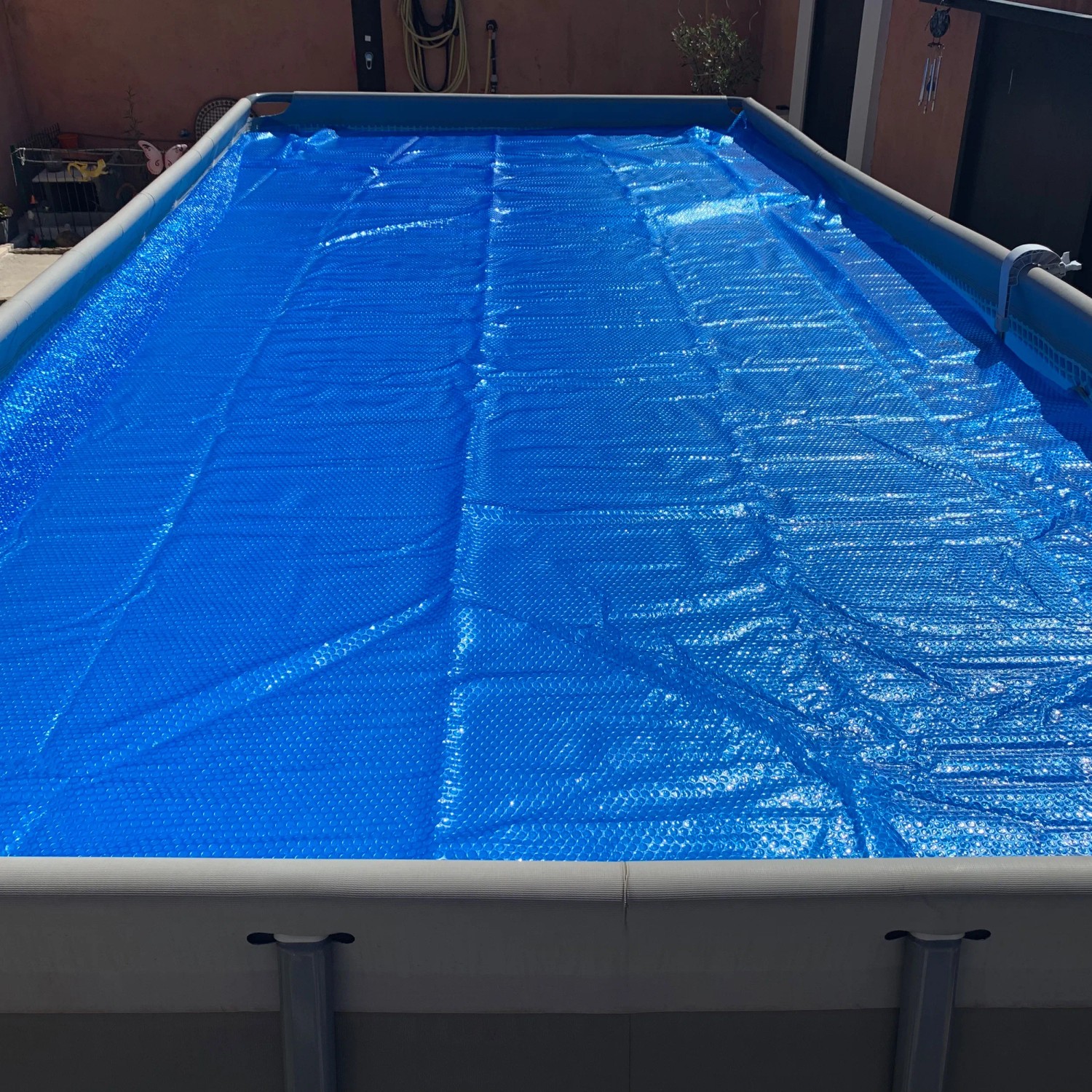 Blau schimmernde Summer Fun Pool Solarfolie auf Rechteckpool, Luftpolsterstruktur.