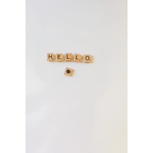 Fix-o-moll Magnete: "HELLO" aus Holzbuchstaben an weißer Wand befestigt.