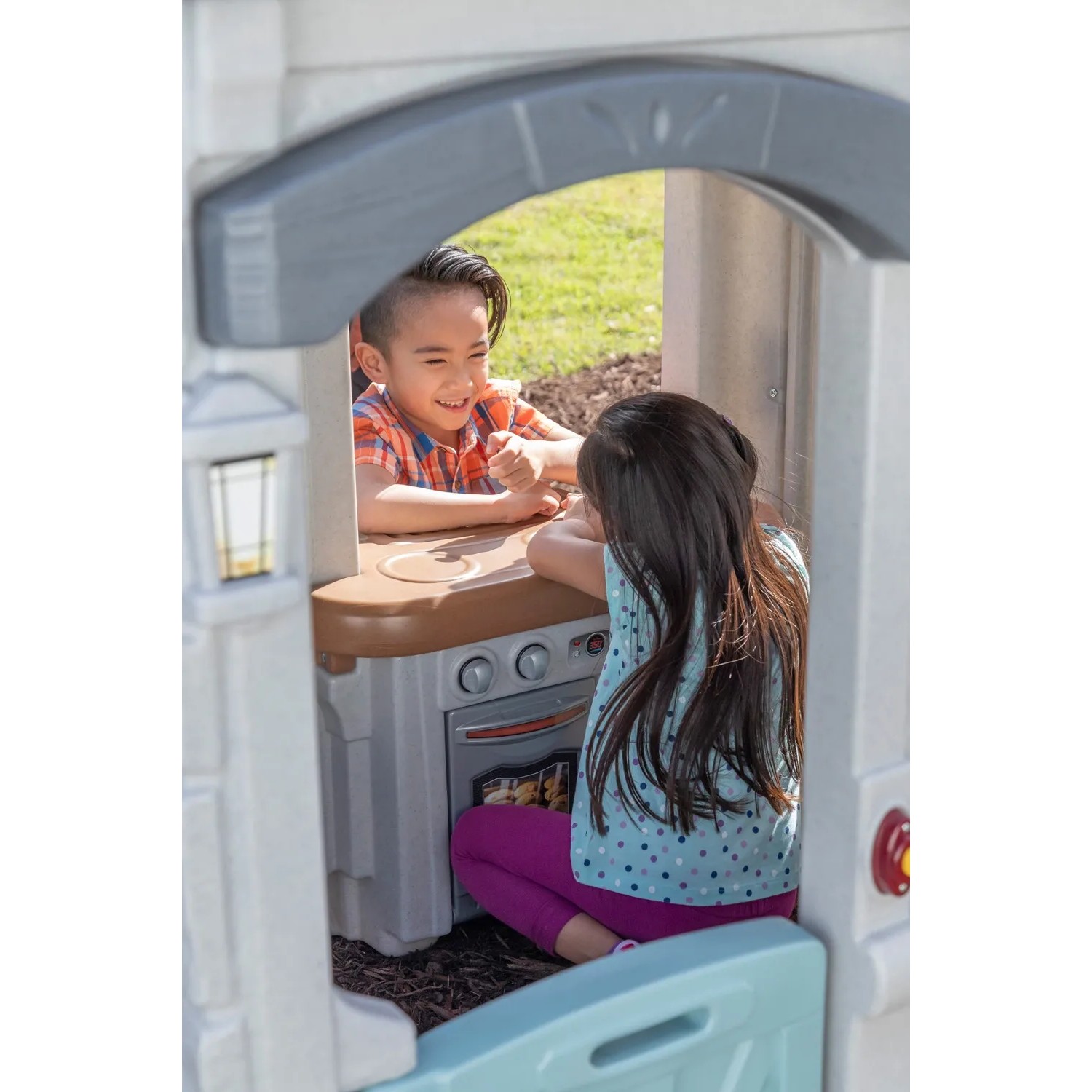 Kinder spielen im Step2 Spielhaus Adventures mit Küche und Ofen.