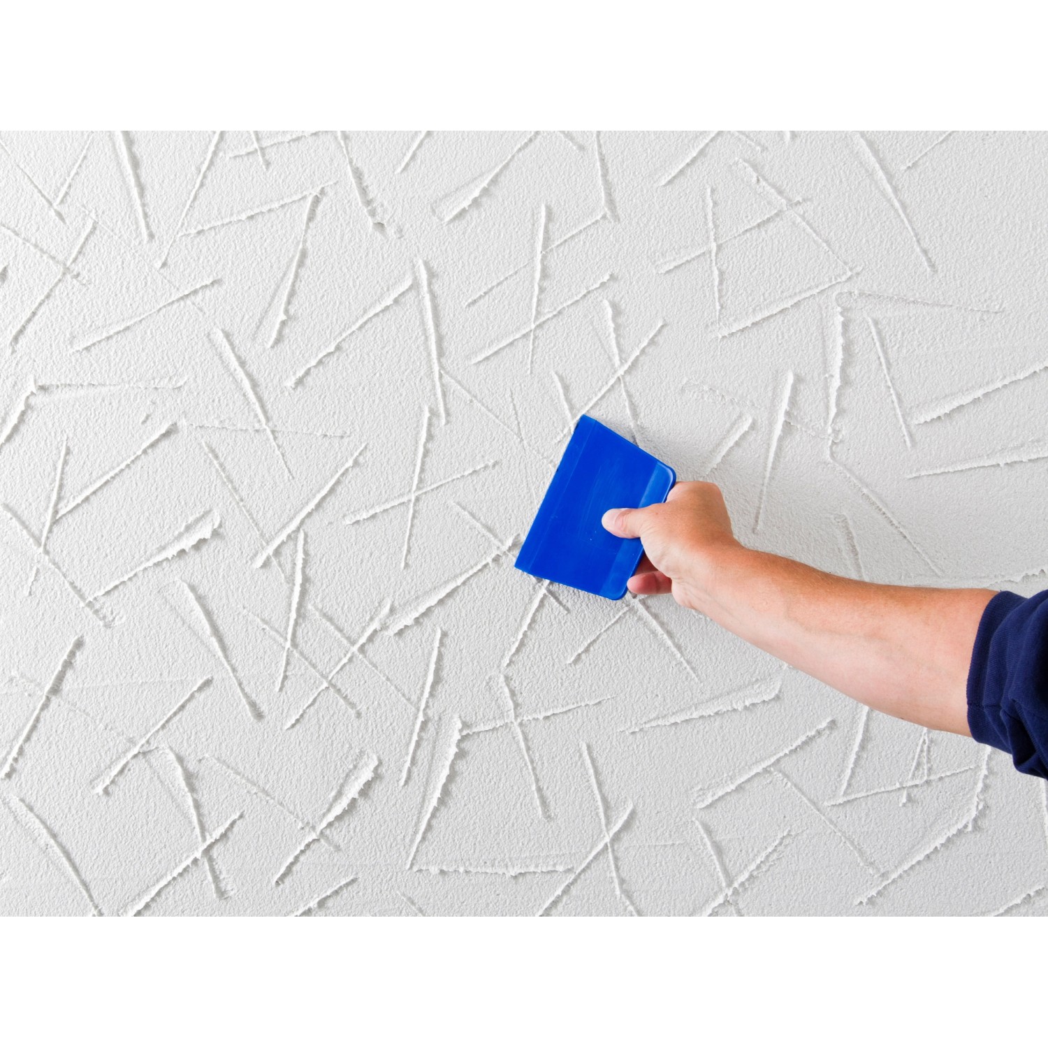 Auftragen von Knauf Royal Fertigputz Reibeputz (2mm) auf eine Wand mit einer blauen Spachtel.