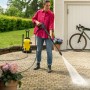 Frau reinigt Terrasse mit gelbem Kärcher Hochdruckreiniger K 4 Premium.