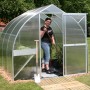 KGT Gewächshaus Alu blank 5,15 m² mit Frau und Gartengeräten im Garten.