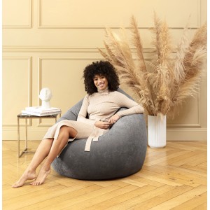 Frau sitzt entspannt im grauen Sitting Point Sitzsack BeanBag (300 l).