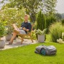 Gardena Smart Sileno Max Mähroboter auf Rasen, Mann entspannt im Garten. Automatischer Rasenmäher für bis zu 1200 m².