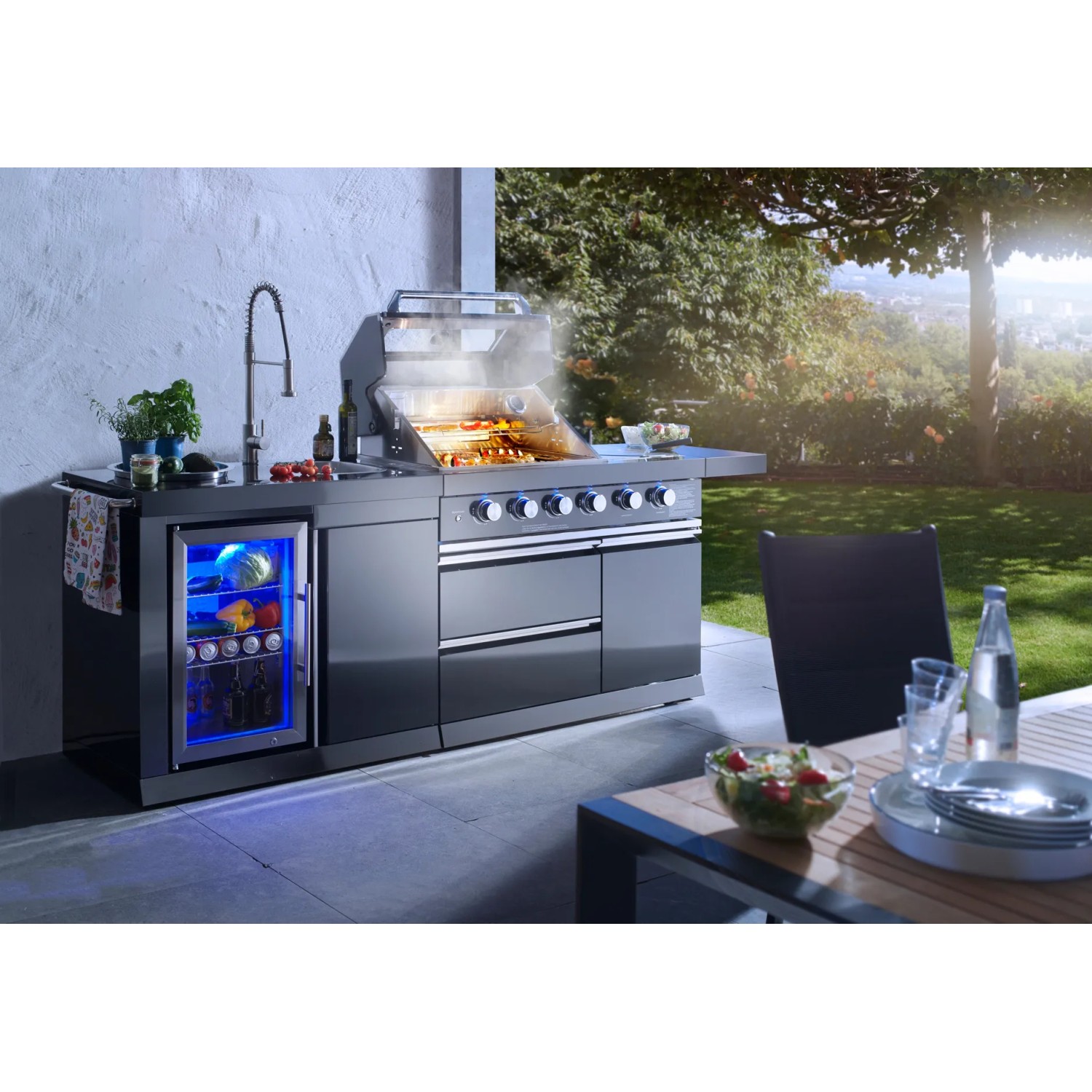 Buschbeck Outdoorküche Cambridge mit Gasgrill, Spüle und Getränkekühlschrank im Garten.