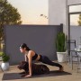 Frau macht Plank mit Hund vor dunkler Juskys Seitenmarkise 300x190 cm als Sichtschutz.