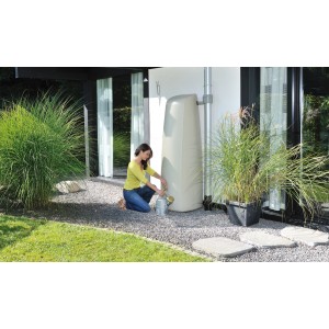 Frau befüllt Gießkanne an Garantia Regenwasser-Wandtank Elegance 400 l in Sandbeige.
